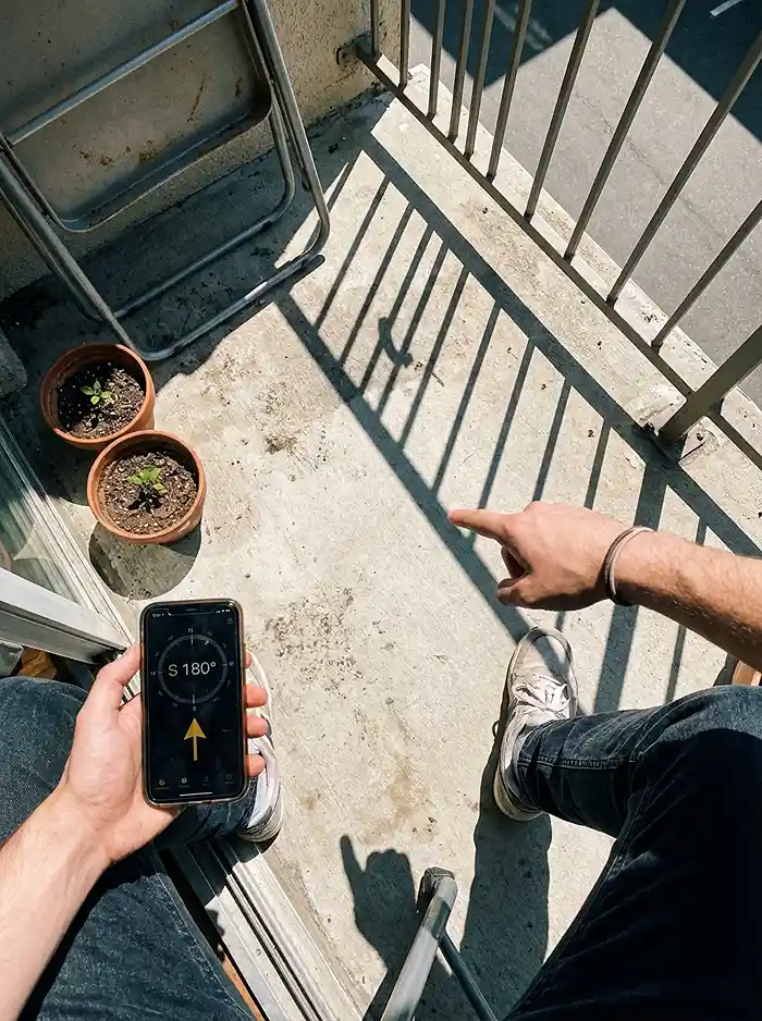 Why Your Balcony Garden Isn't Growing 2 Checking balcony sun direction with a smartphone compass app for plant placement