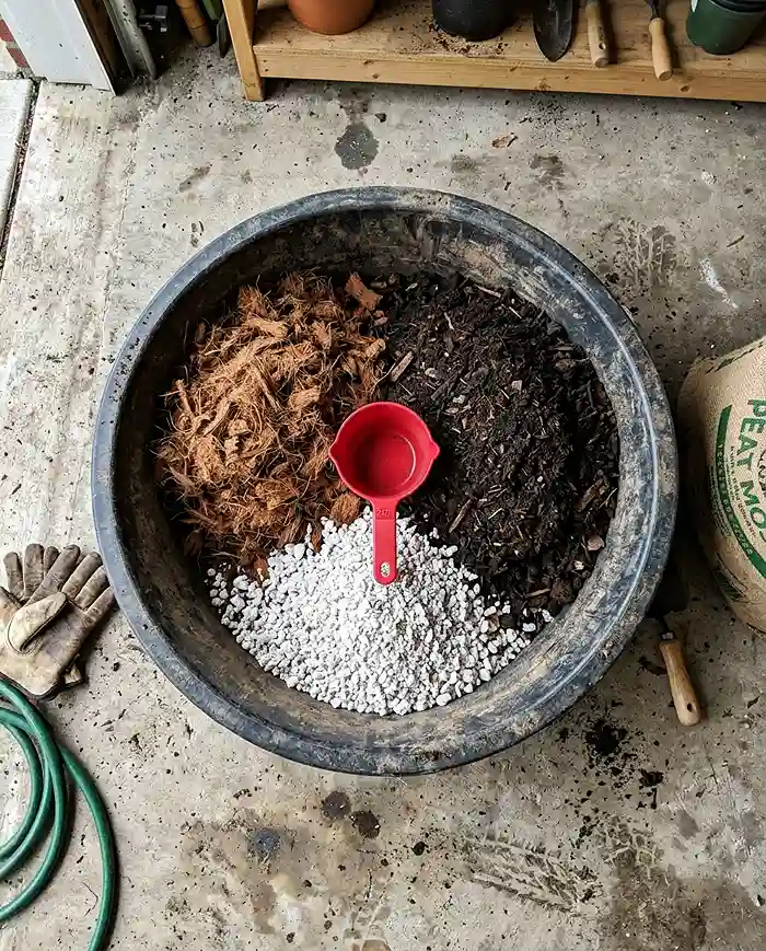 Best Soil and Fertilizer for Container Vegetable Gardens 3 DIY potting mix ingredients with coir compost and perlite in mixing tub
