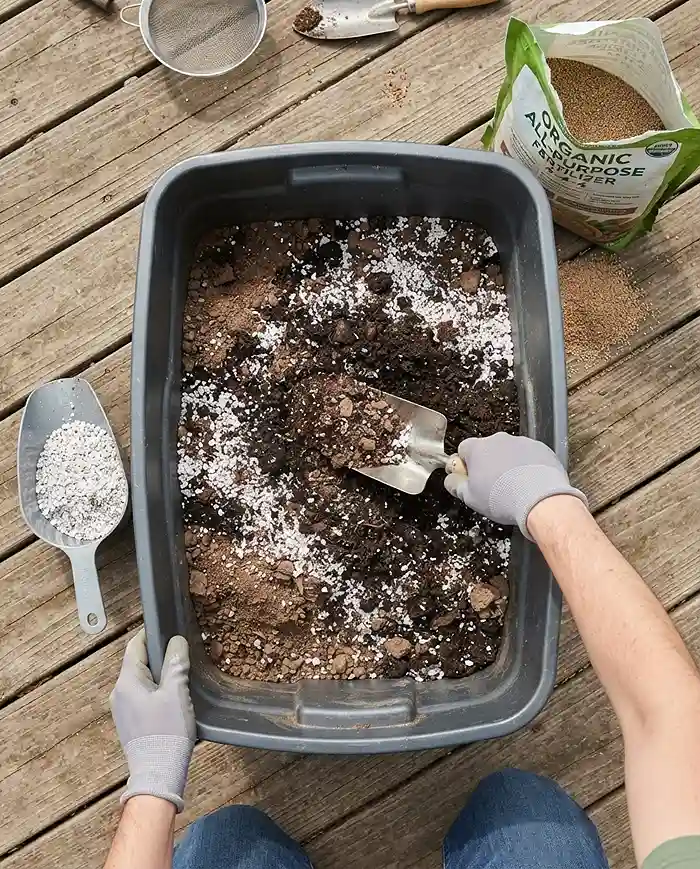 How to Reuse Potting Soil Safely for a New Season 4 Blending sifted old soil with fresh compost, perlite, and fertilizer in a tote to rebuild a complete potting mix