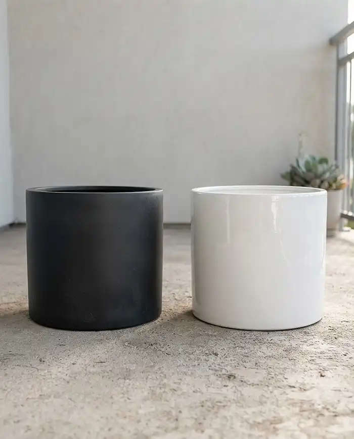 Monochromatic Balcony Garden Ideas for Fall 2 Matte black resin planter beside a glossy white ceramic pot showing contrasting finishes