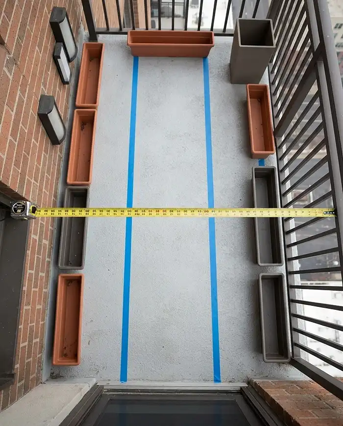 Narrow Balcony Planters That Save Space 2 Painter tape marking a 24-inch clear walkway and a tape measure spanning wall to railing on a narrow balcony