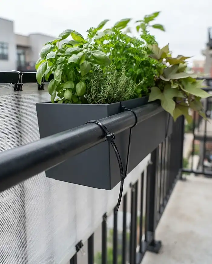 Hanging Planters for Balcony Railing That Save Space 5 Railing box base secured with zip ties beside a mesh windbreak to prevent tipping and wind damage