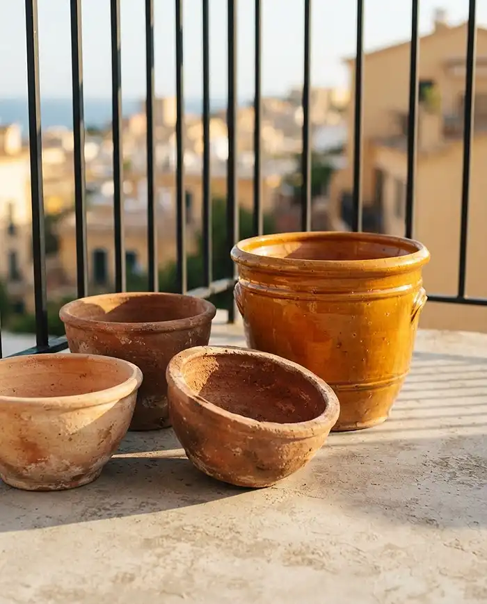 Mediterranean Balcony Tablescape with Herbs and Citrus 2 Unglazed terracotta bowls and a glazed ceramic cachepot in warm earth tones for a Mediterranean tablescape